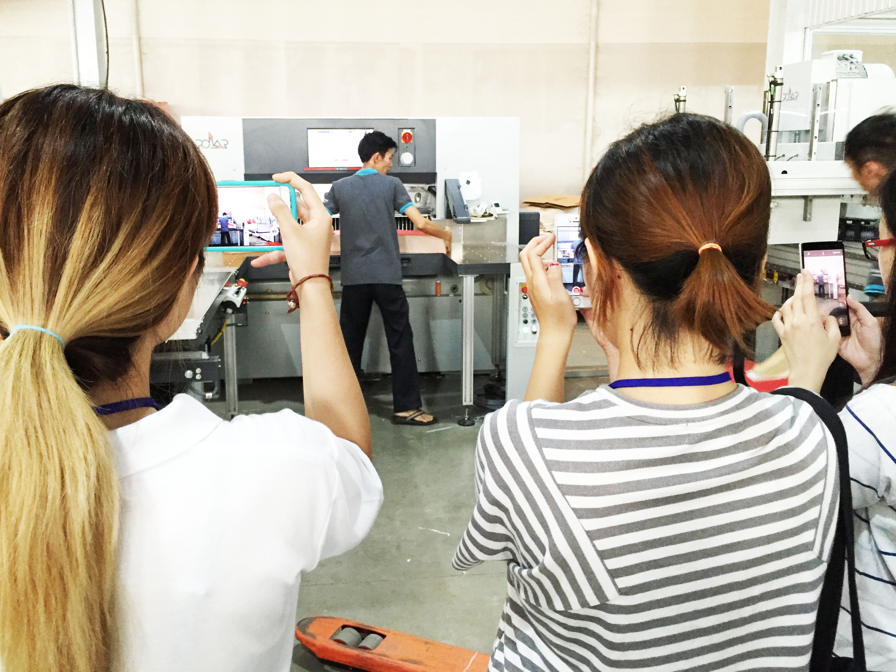 A mix of digital and traditional methods as students take pictures of the printing process.