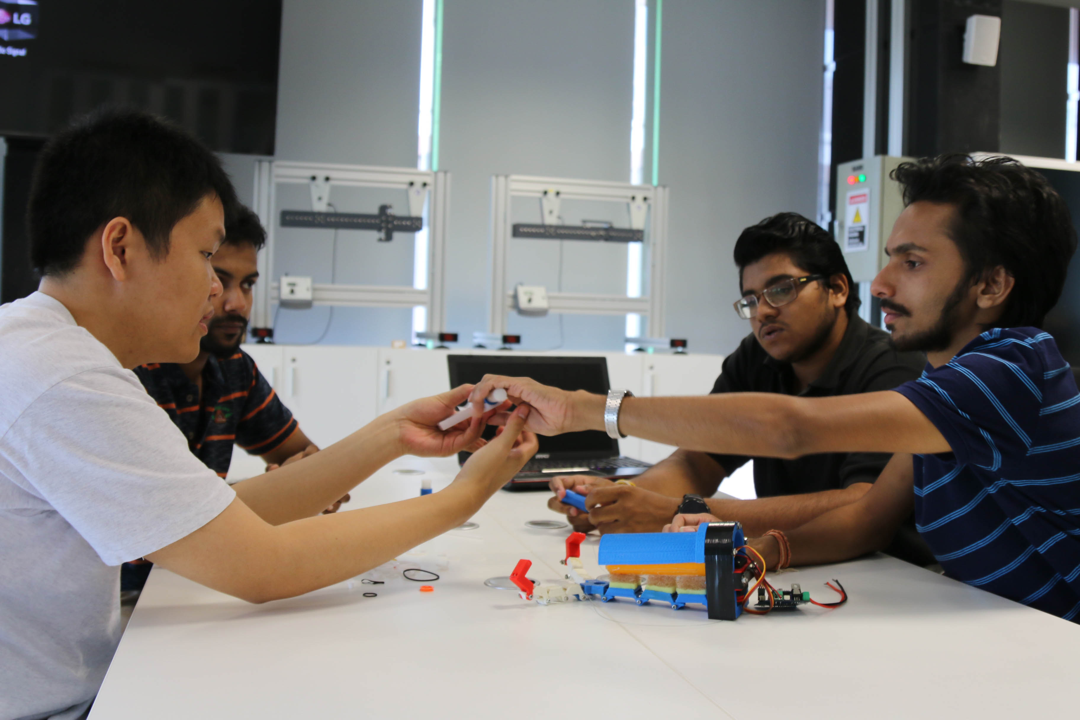 The students discussing the mechanical prototype of the prothesis arm.