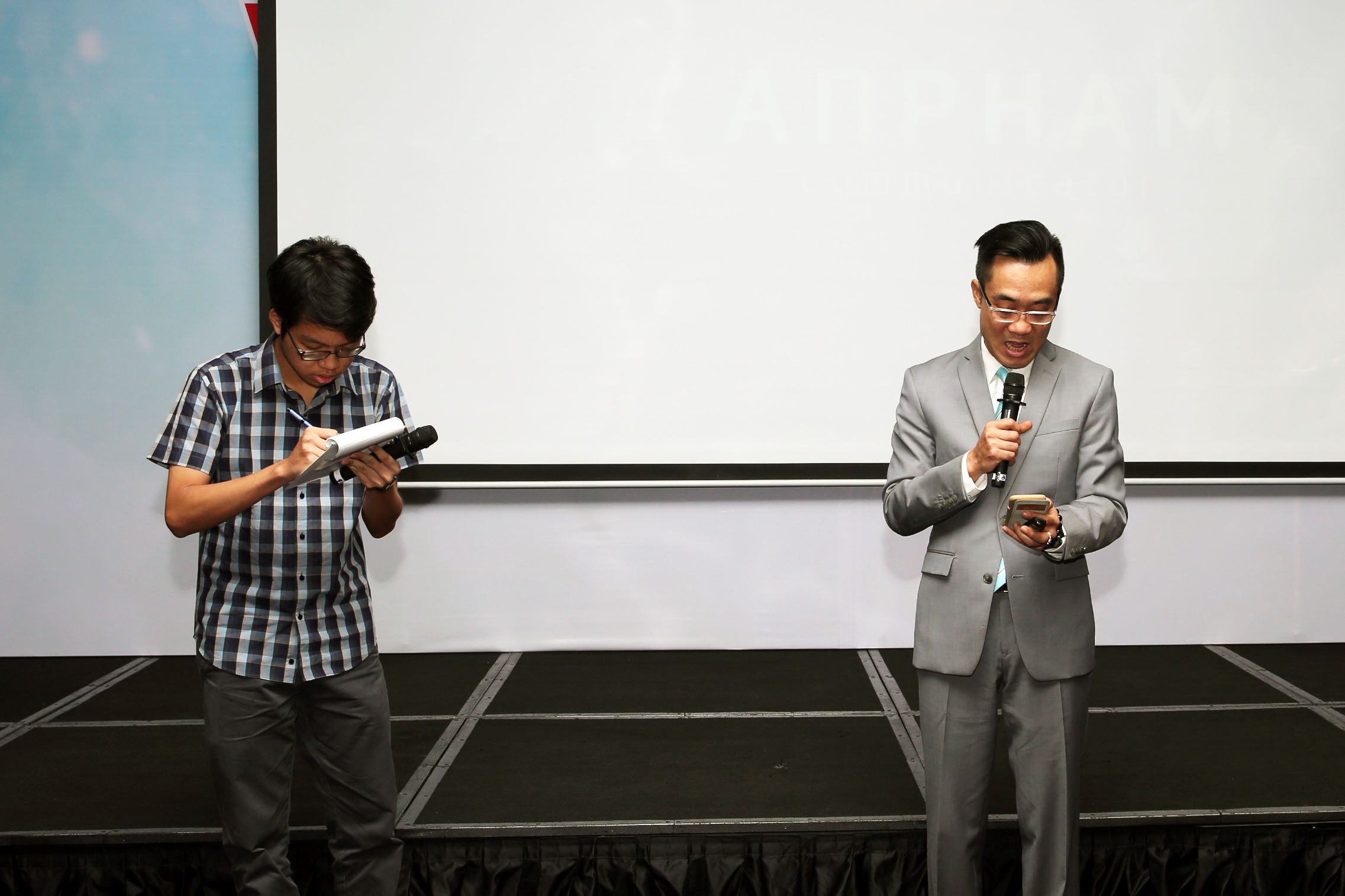 Ông Phạm Xuân Hoàng Ân (phải), thông dịch viên giàu kinh nghiệm, cùng một bạn sinh viên thể hiện công việc thông dịch