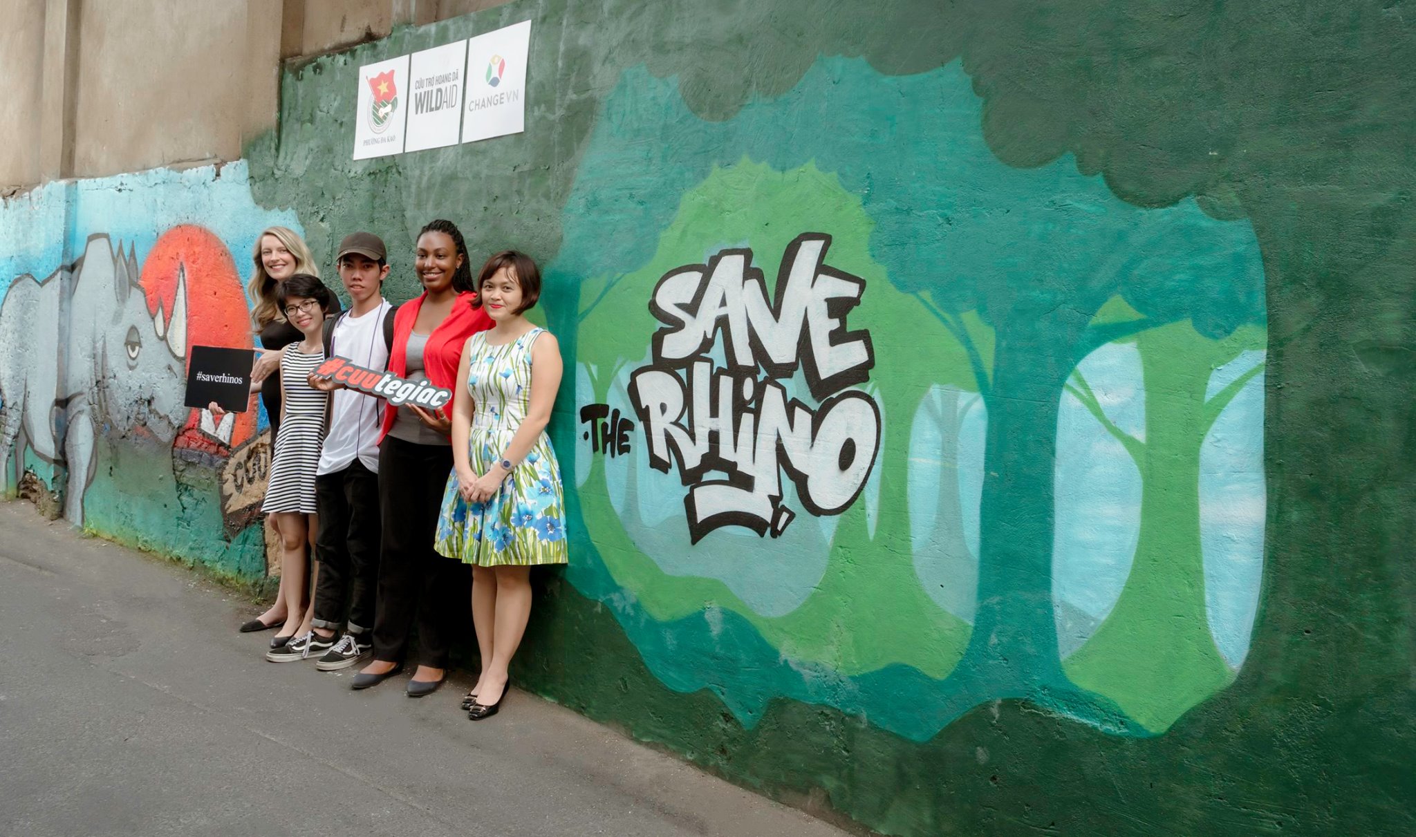 Châu Nhi (thứ hai từ trái sang) với nhóm vẽ tranh tường trong dự án bảo vệ tê giác ở Việt Nam.
