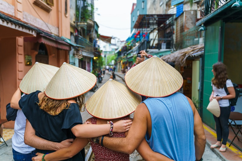 four tourists wearing Vietnamese conical hats