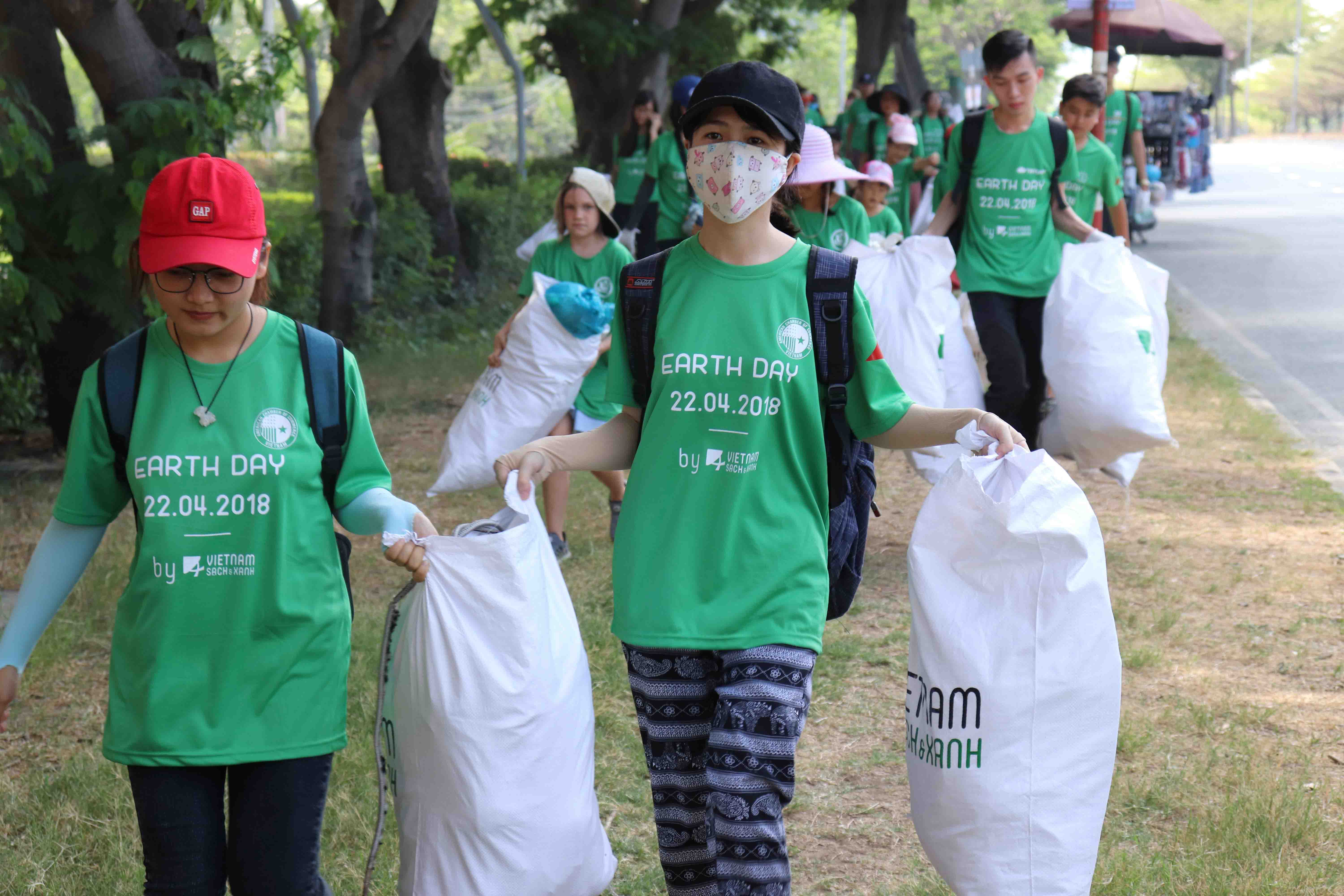 Các tình nguyện viên thu gom rác trên đường Nguyễn Văn Linh, một tuyến đường đông đúc ở Quận 7, TP. Hồ Chí Minh.