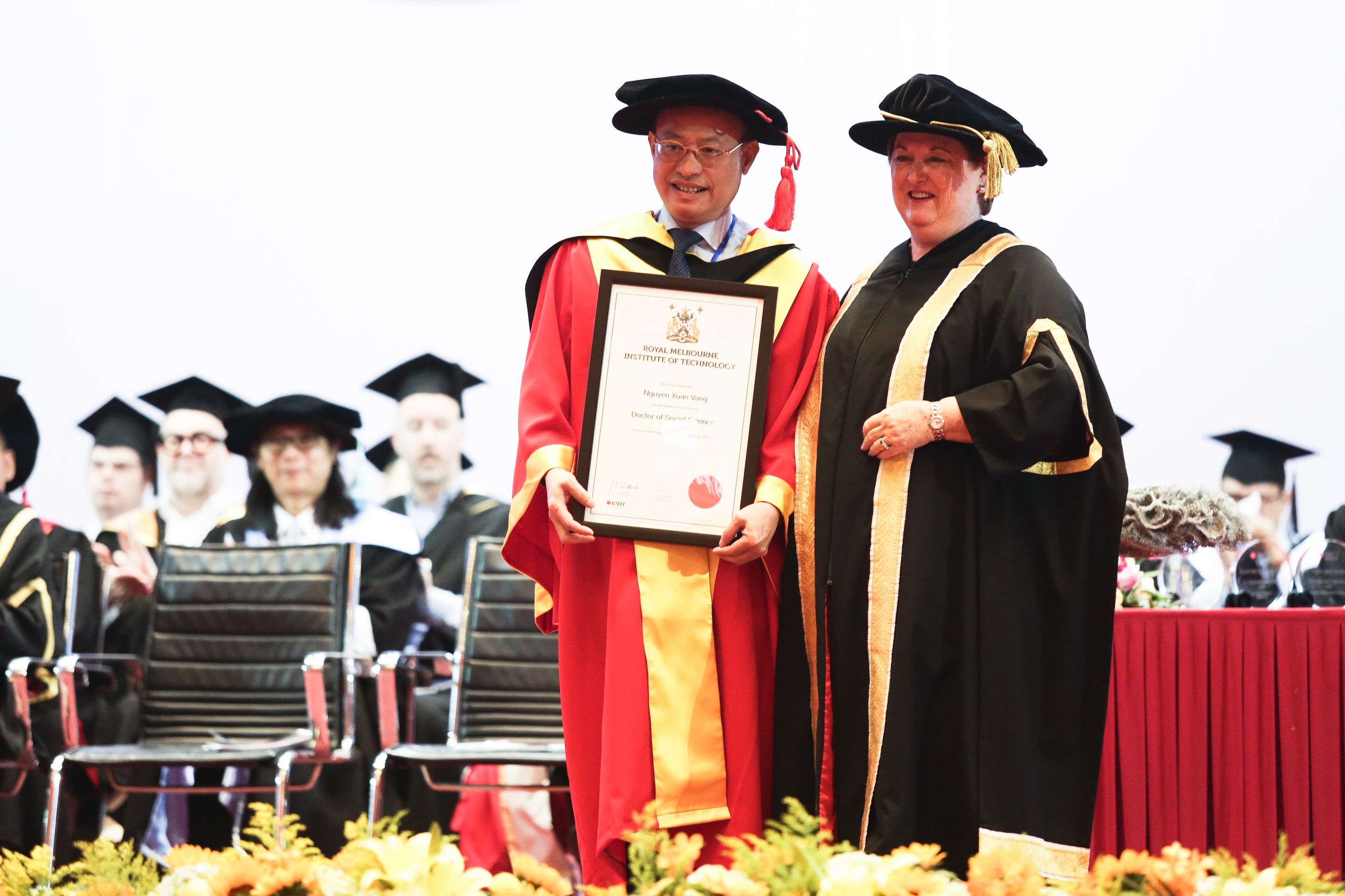 Thừa hành chủ tịch Hội đồng Đại học RMIT trao bằng Tiến sĩ Danh dự cho ông Nguyễn Xuân Vang, nguyên Cục trưởng Cục Hợp tác quốc tế thuộc Bộ Giáo dục và Đào tạo.
