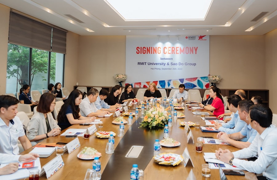 Delegates at the signing ceremony sitting at a long table