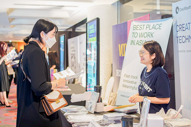 An exhibitor speaking with a guest at the One Mount booth.