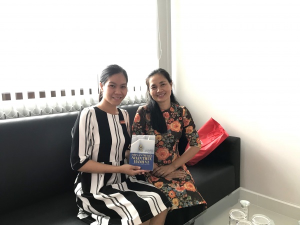 Ms Le Thi Minh Tam (right) gifting her book entitled Tiep can tri lieu nhan thuc hanh vi which is about psychological counselling and mental health support