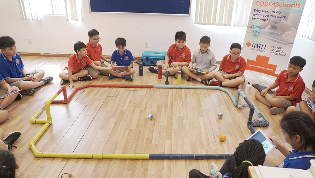 Học sinh tại trường Quốc tế TAS thực hành lập trình robot Sphero trong một buổi học của CODE4Schools. 