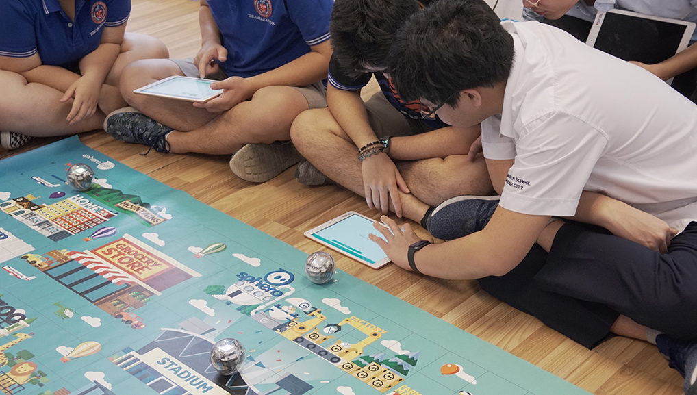 Students working together to properly control Sphero robots during a workshop.