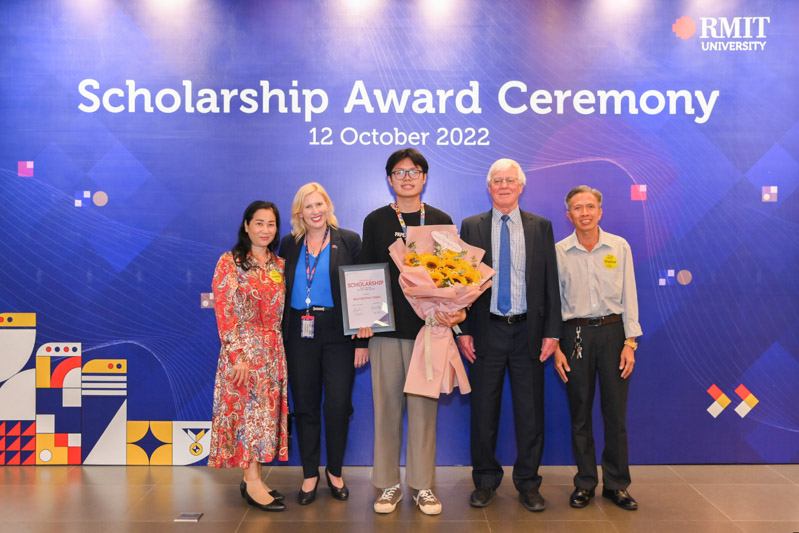 Thinh (pictured in the centre) with family and RMIT University leaders.