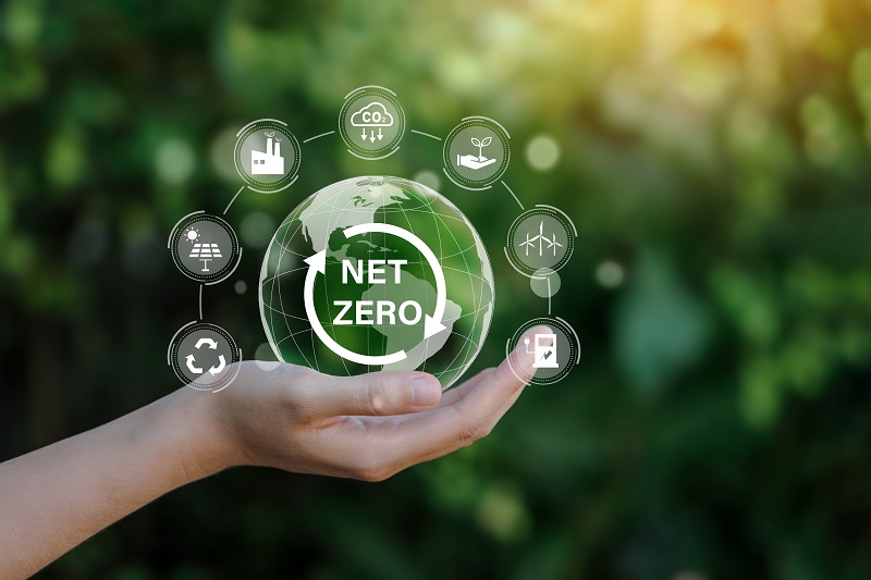 Net zero icon and carbon neutral concept in the hand for net zero greenhouse gas emissions target Climate neutral long term strategy on a green background