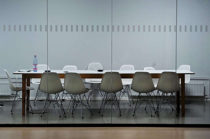 Empty chairs around a table in a meeting room