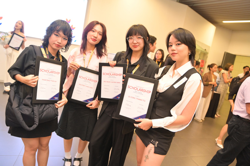 Four scholarship winners pose with their certificates