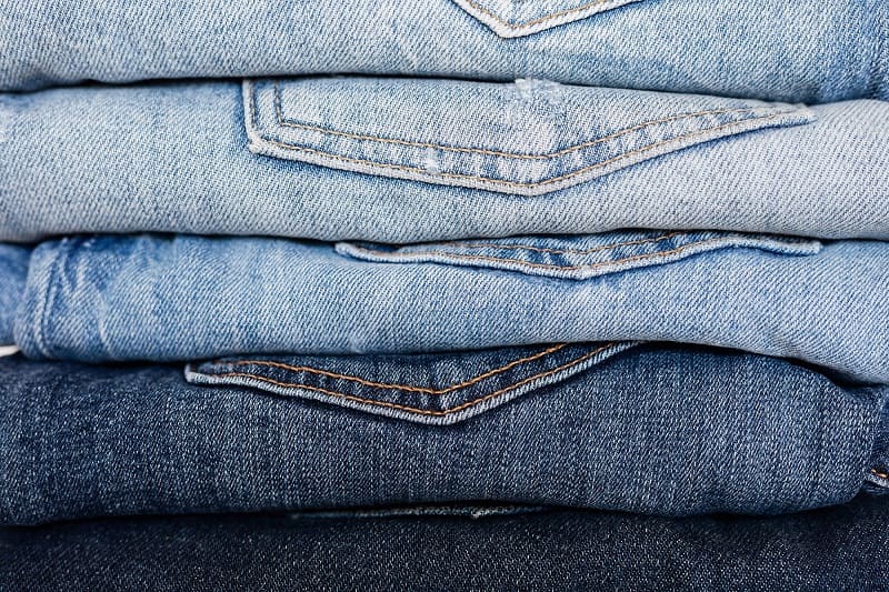 Stack of blue denim clothes in different shades
