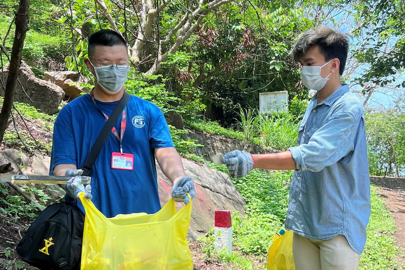 Two RMIT students collecting trash.