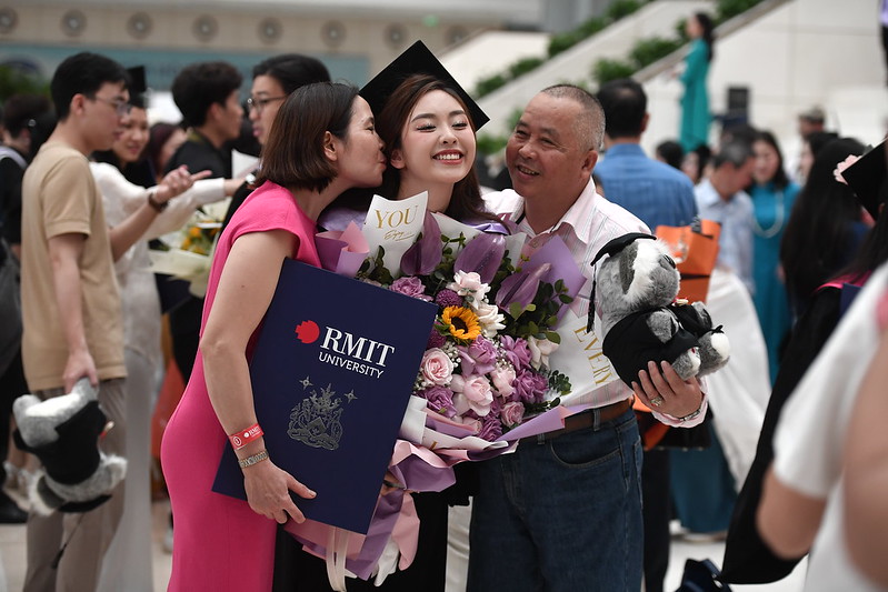 Parents pose with a smiling RMIT fresh graduate