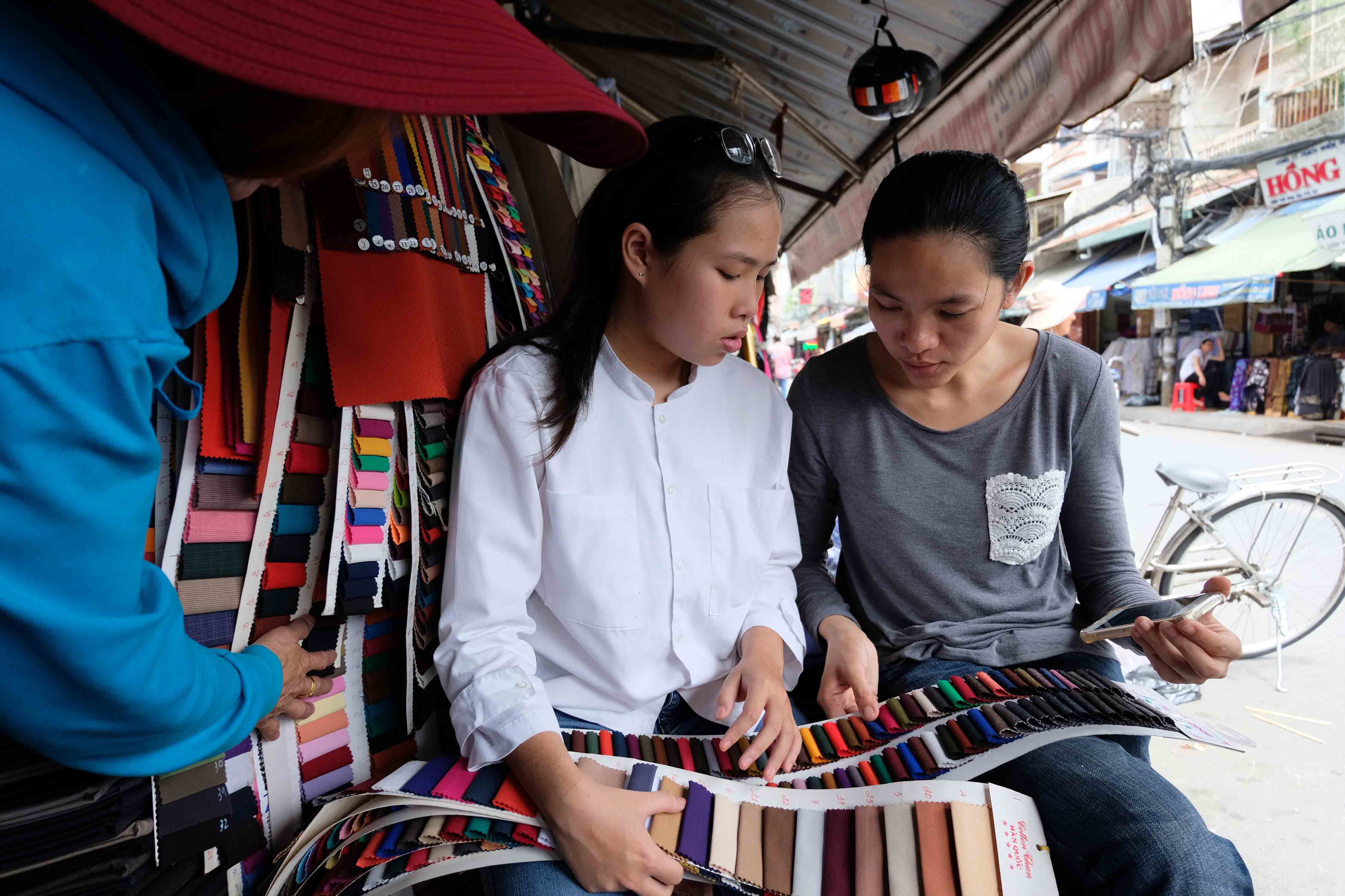 Giang chọn vải ở chợ để lên sản phẩm từ bản phác thảo. 