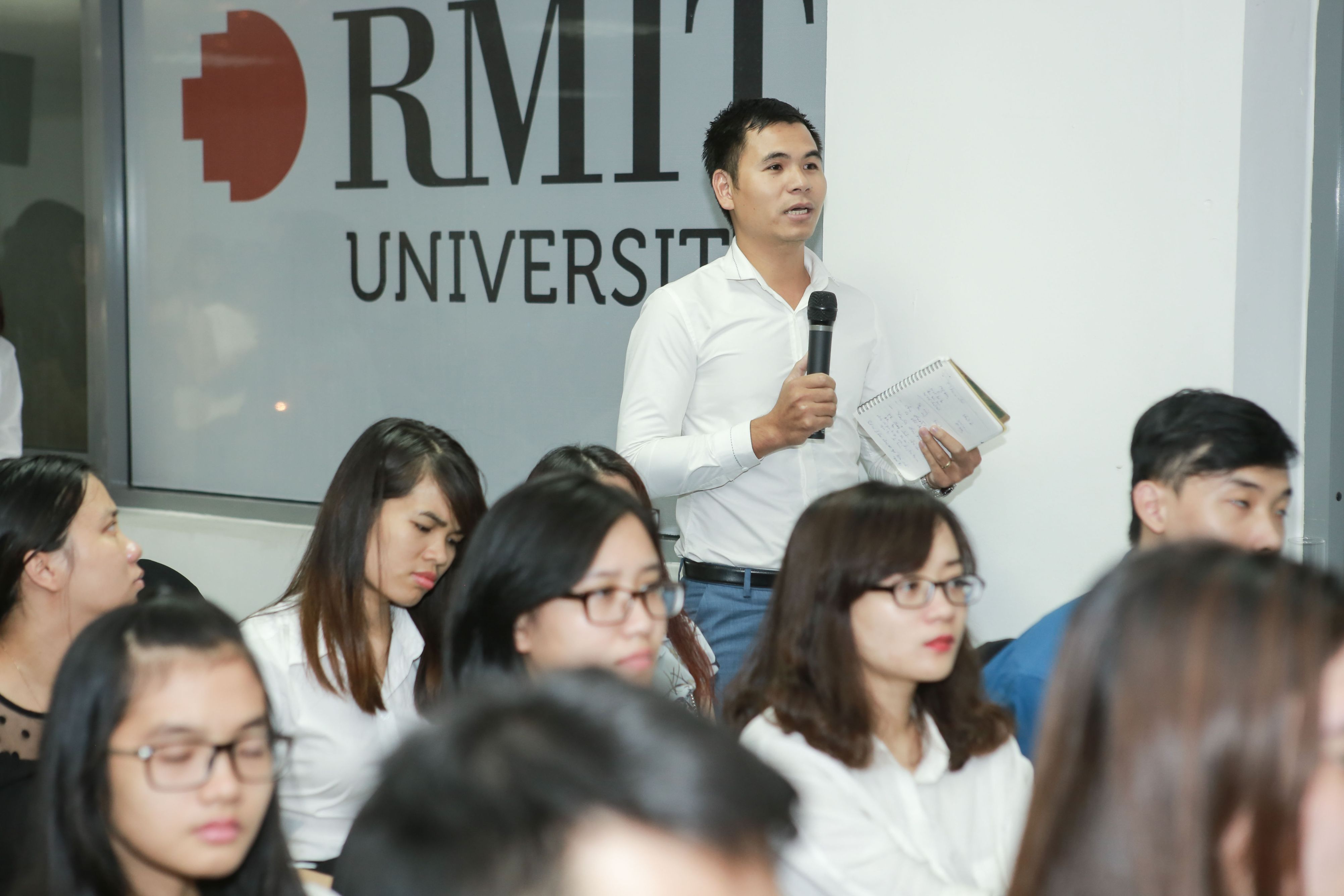 An audience member poses a question to the speakers.