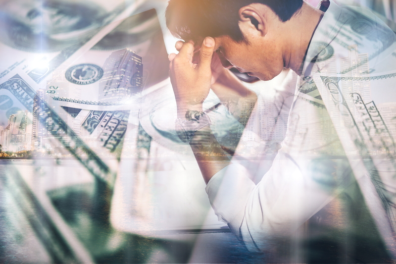 portrait-of-upset-asian-man-with-hands-squeezing-head-losing-dollars.jpg