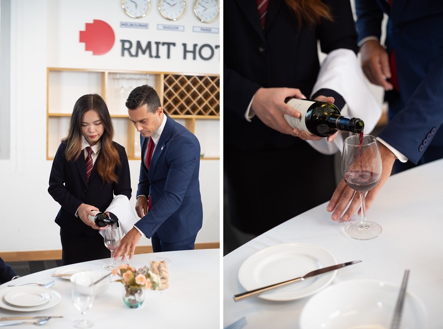RMIT student practices pouring wine for hotel guests with a lecturer