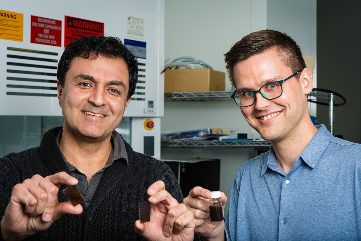Prof. Kourosh Kalantar-zadeh (right) with a pot of solar paint and Dr. Torben Daeneke with a piece of glass applied solar paint.