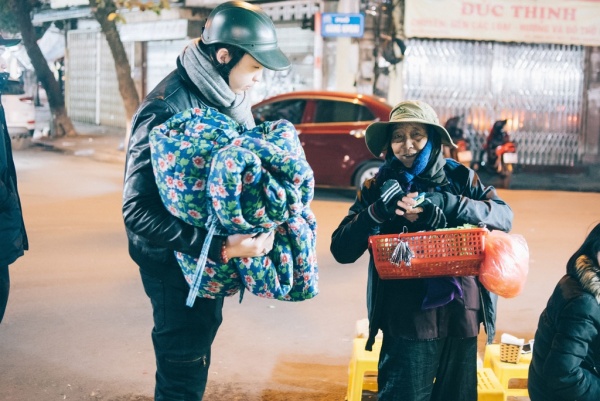 Sinh viên ngành Kinh doanh Lê Minh Chính phát chăn và các nhu yếu phẩm cho một phụ nữ vô gia cư trong đợt rét đậm tại Hà Nội  