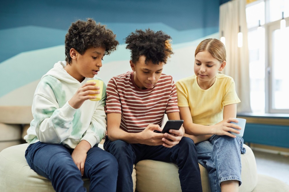 Three children looking at a smartphone