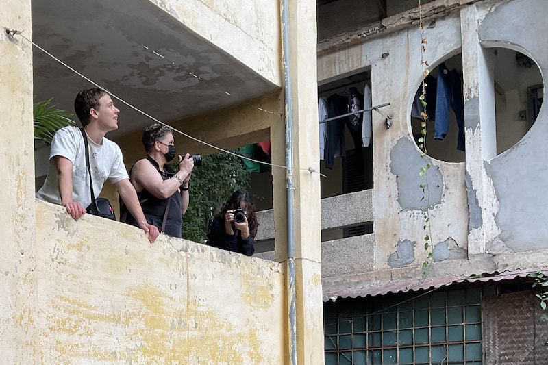 Three people photographing collective housing complex in Hanoi