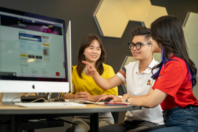 Three students in a computer lab