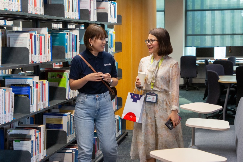two-women-walking-talking-and-smiling-in-rmit-library