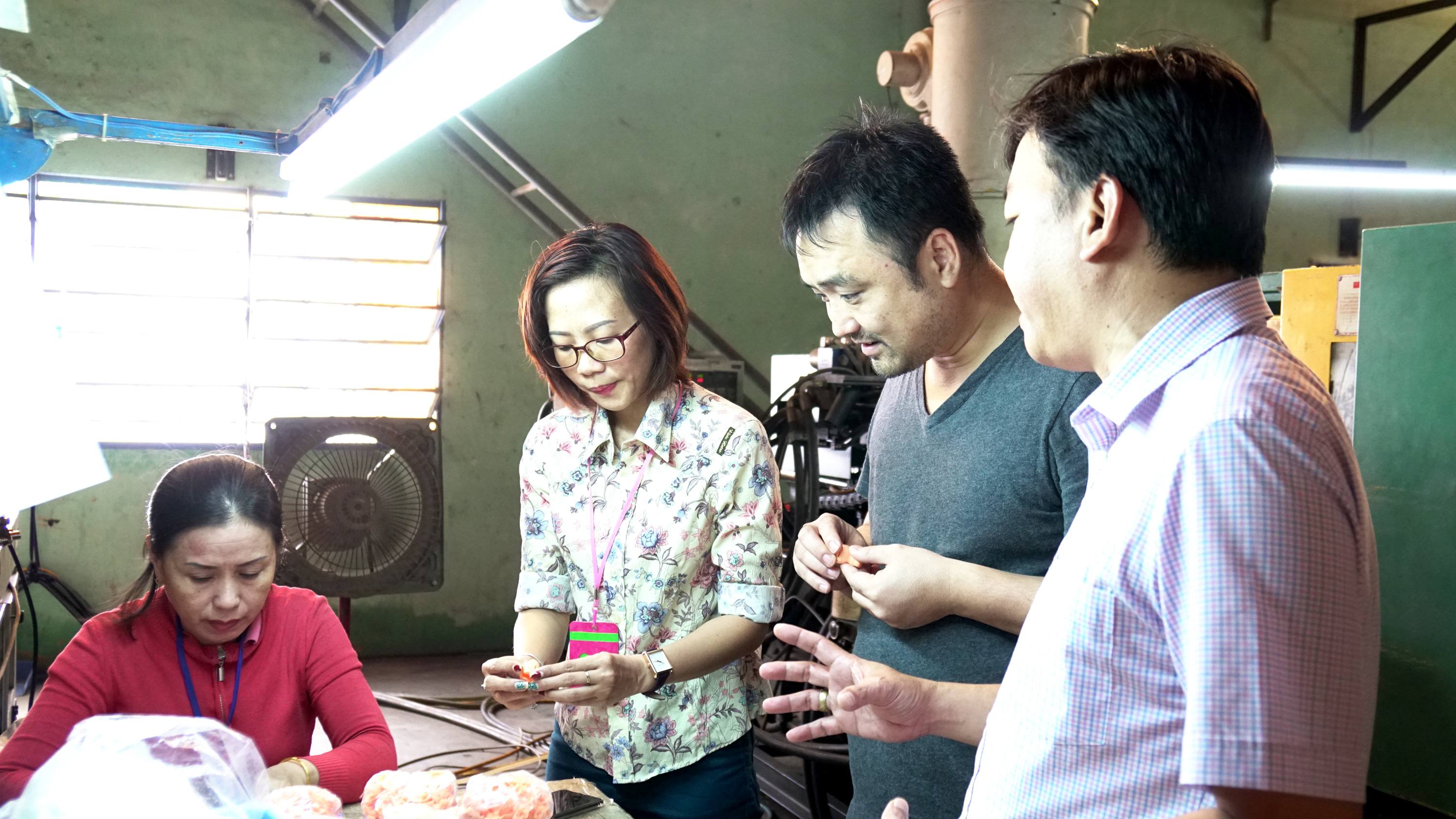 RMIT Vietnam lecturer Tu Nguyen (second from right) checks on the Son Tinh – Thuy Tinh manufacturing process. 