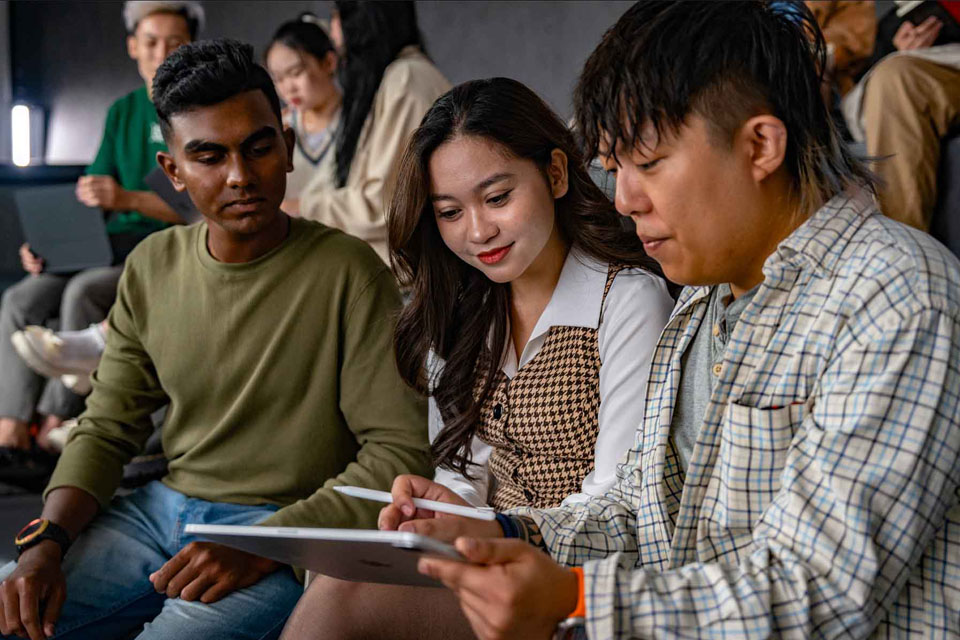 three students discussing work