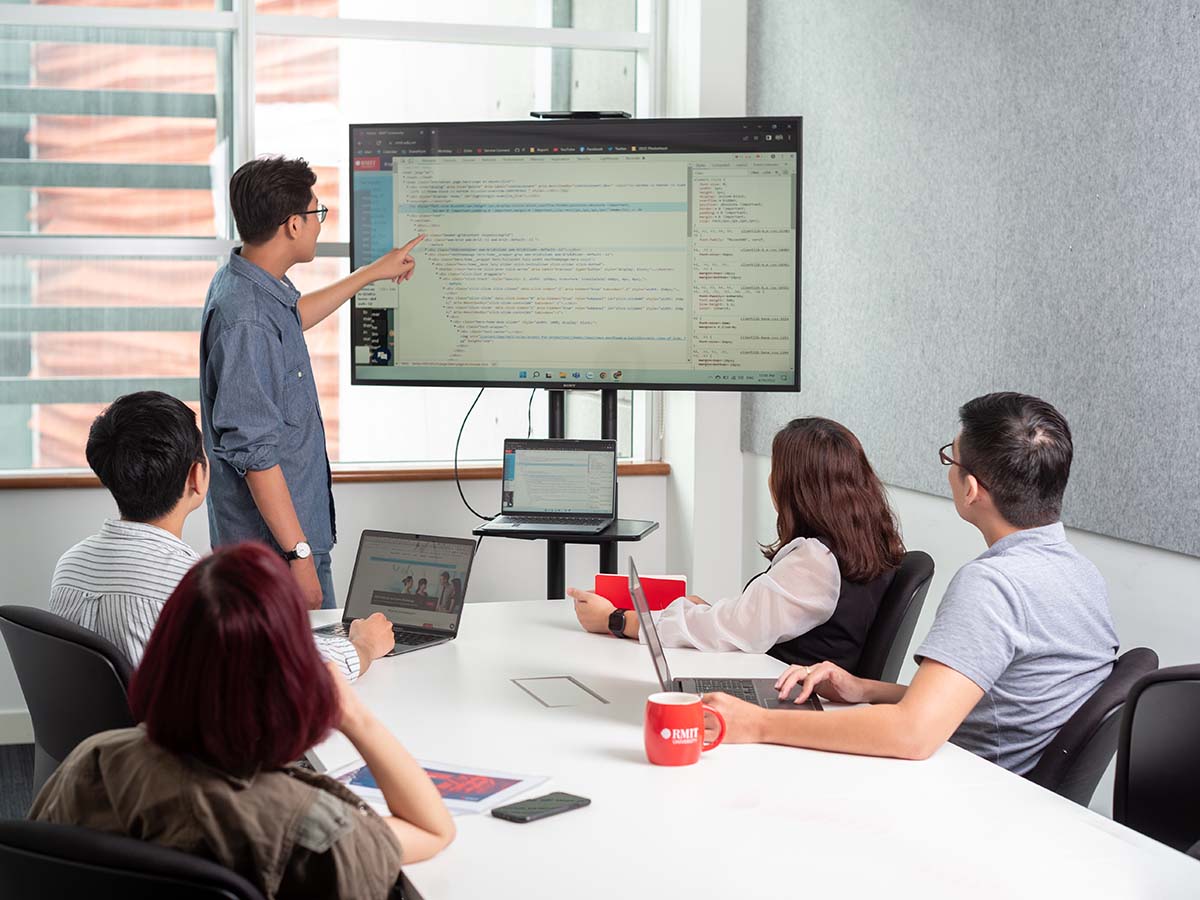 Postgraduate students discussing codes on a screen