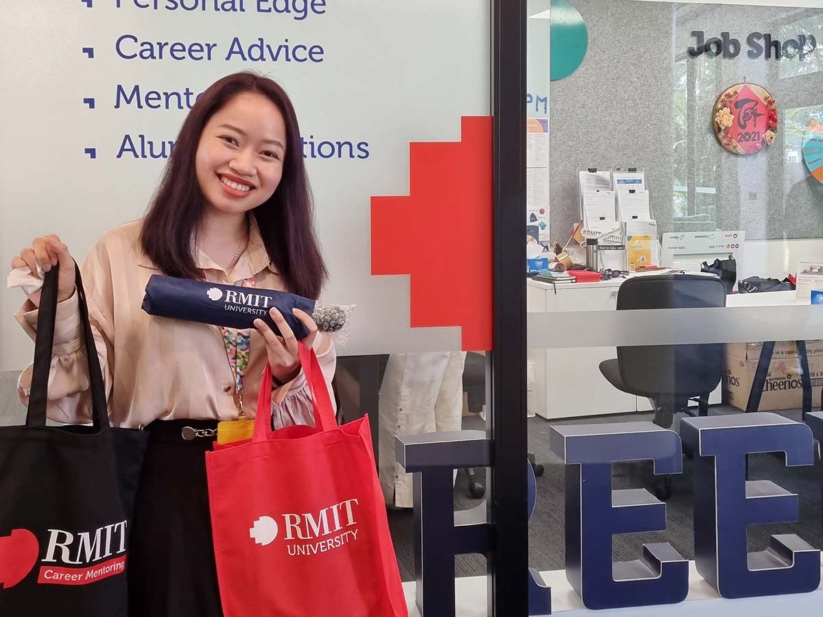Hanh Truong smiling in front of Job Shop in RMIT