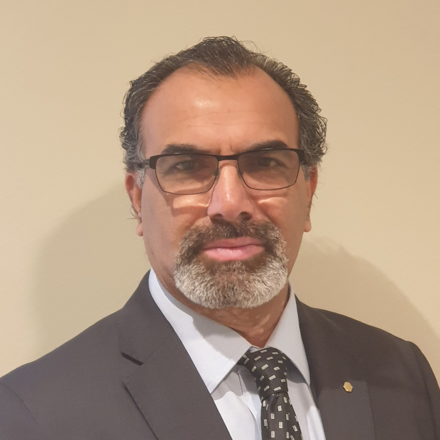 Headshot photo of a middle-aged man with glasses and mustache and wearing a suit