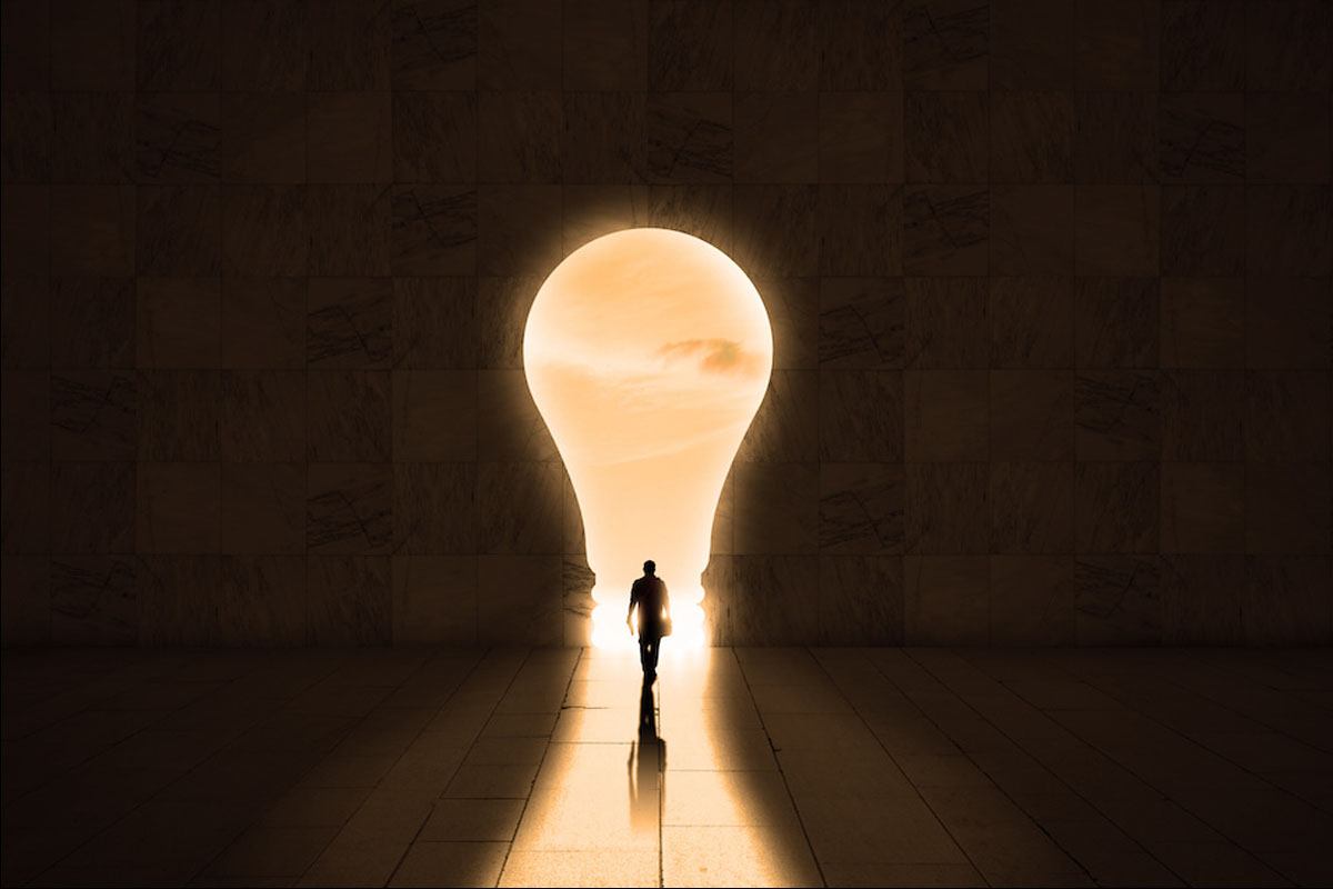 a man walking towards a lightbulb 