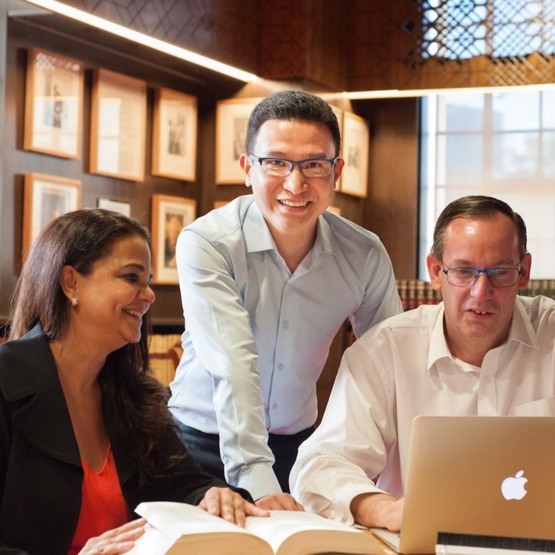 Group with laptop and book