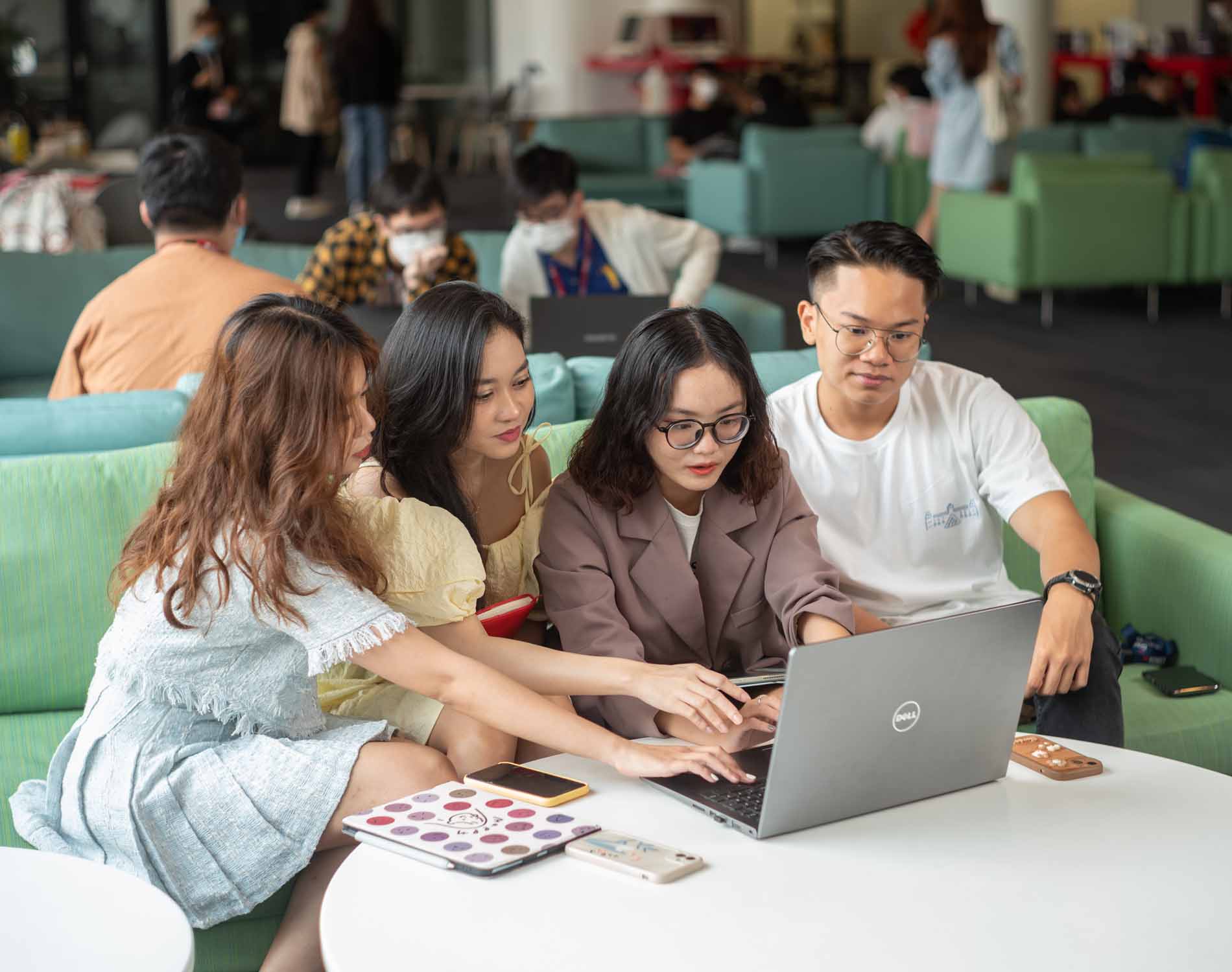 group of students pointing at the laptop