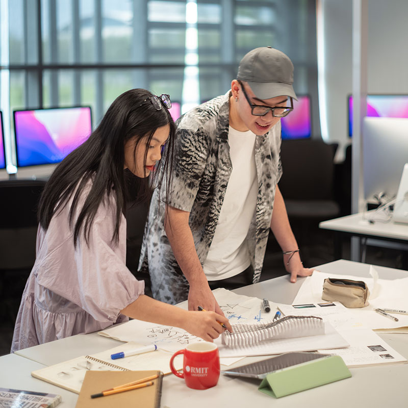 Two students discussing an art model