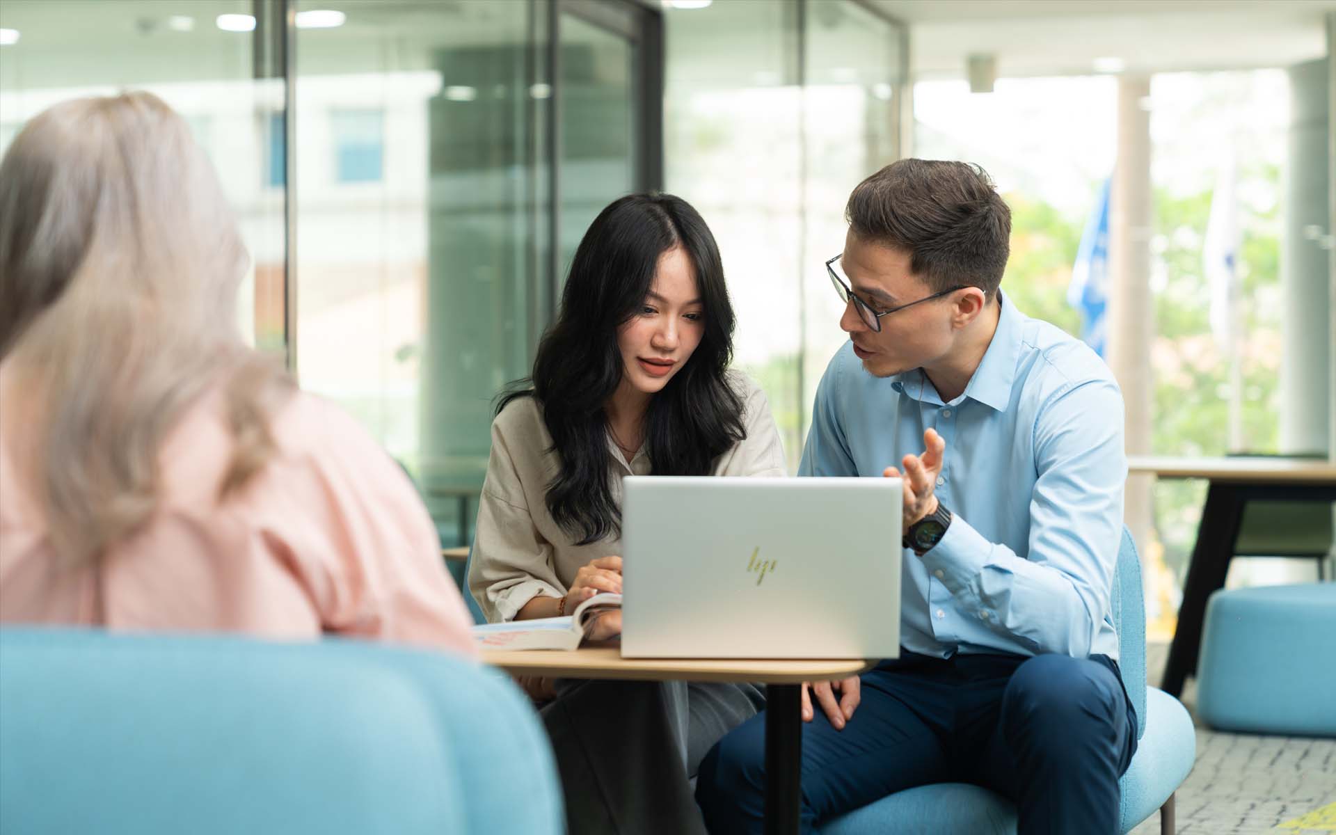 a female student and a male lecturer working on laptop together