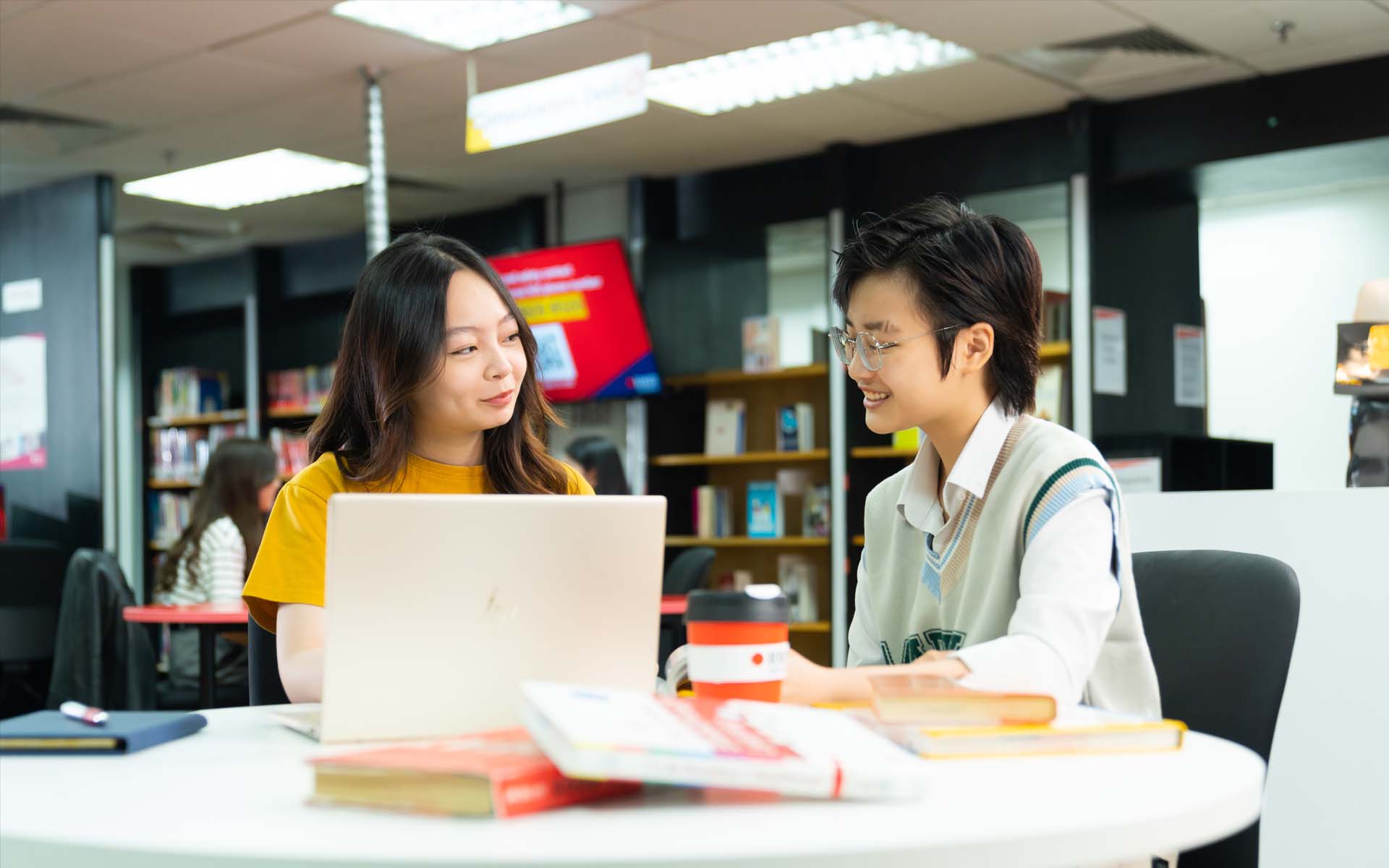 two students one female and one neutral gender talking with each other on campus