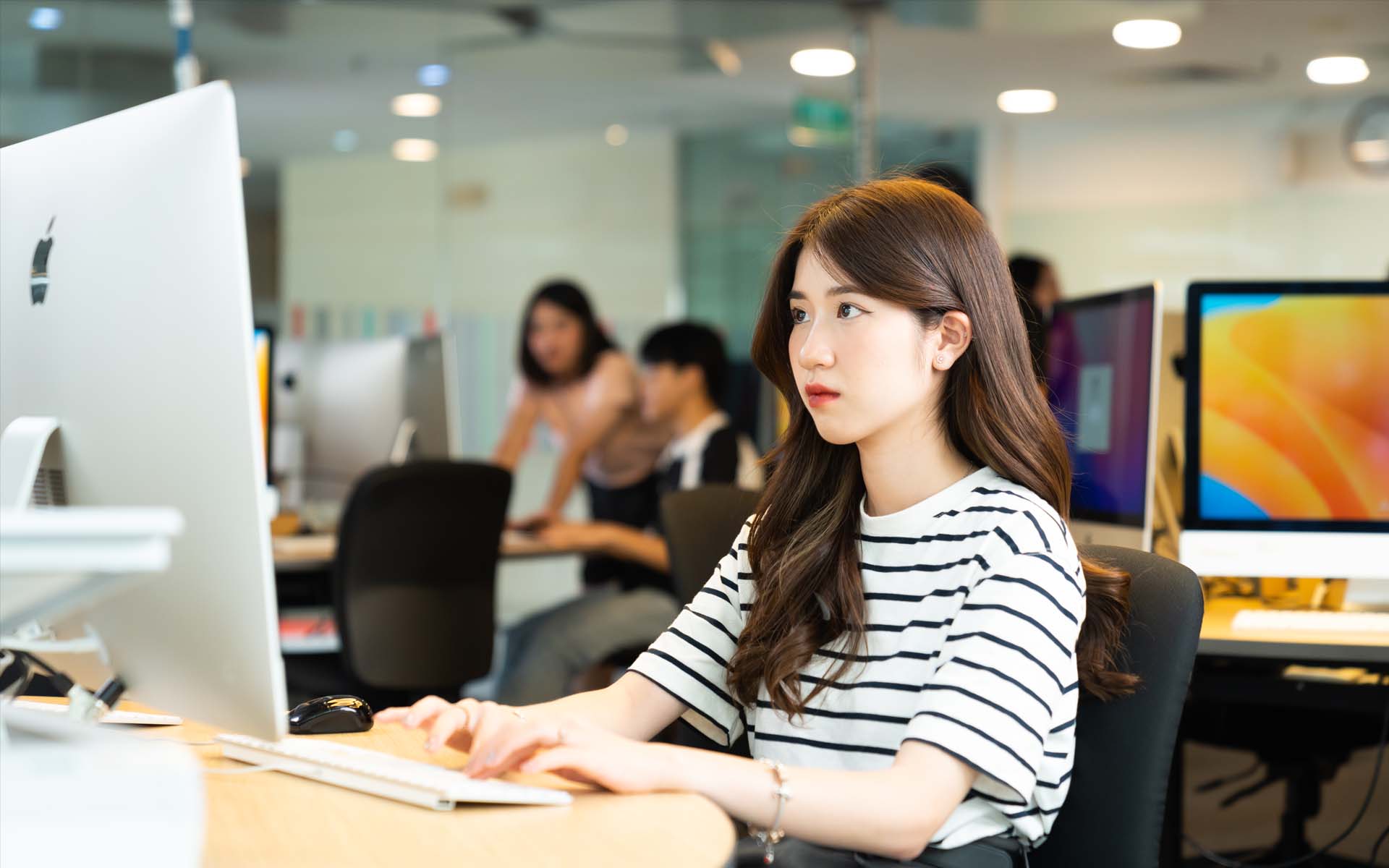 a female student is working on a computer in HN campus