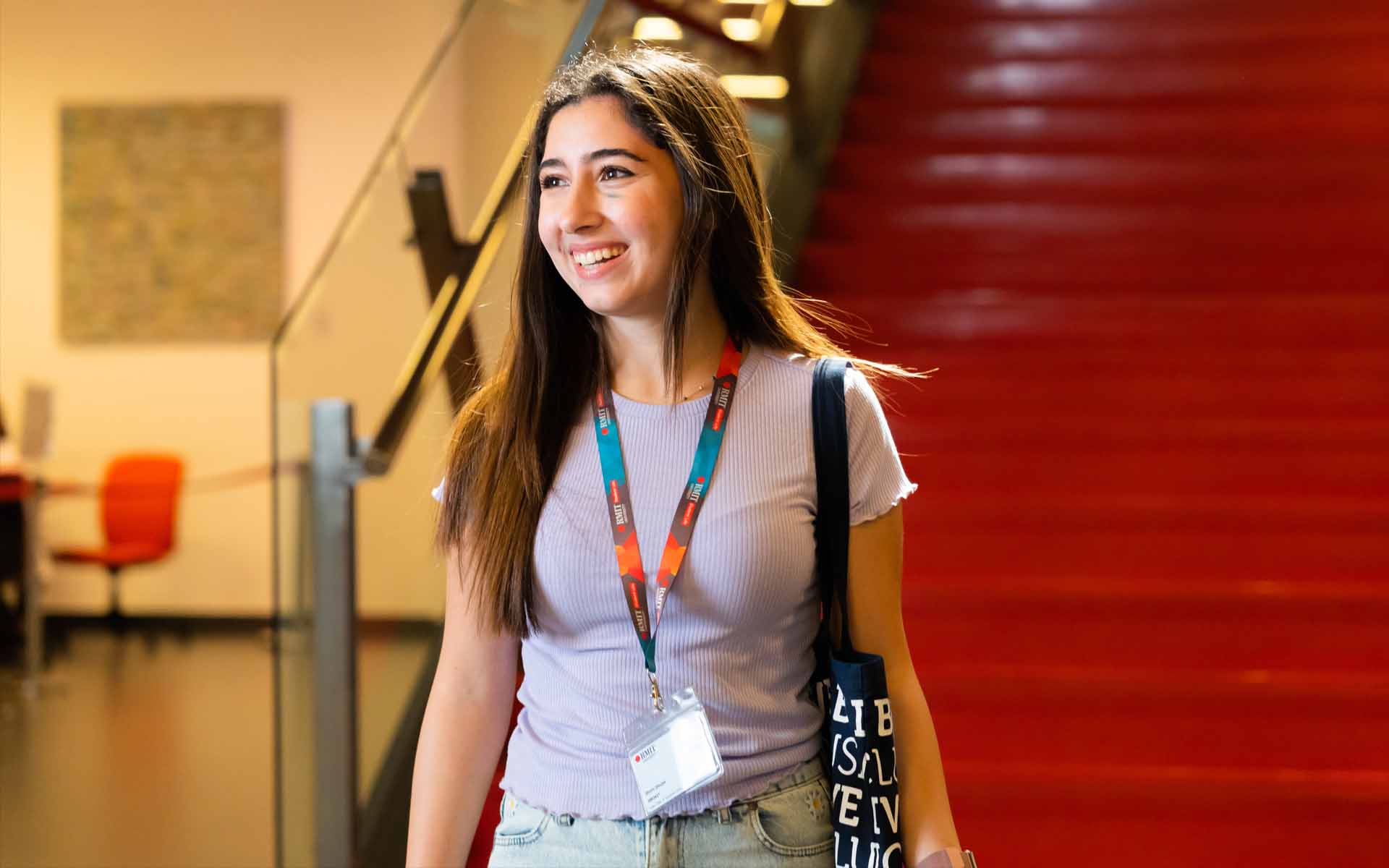 a female student sitting in a lobby of university campus