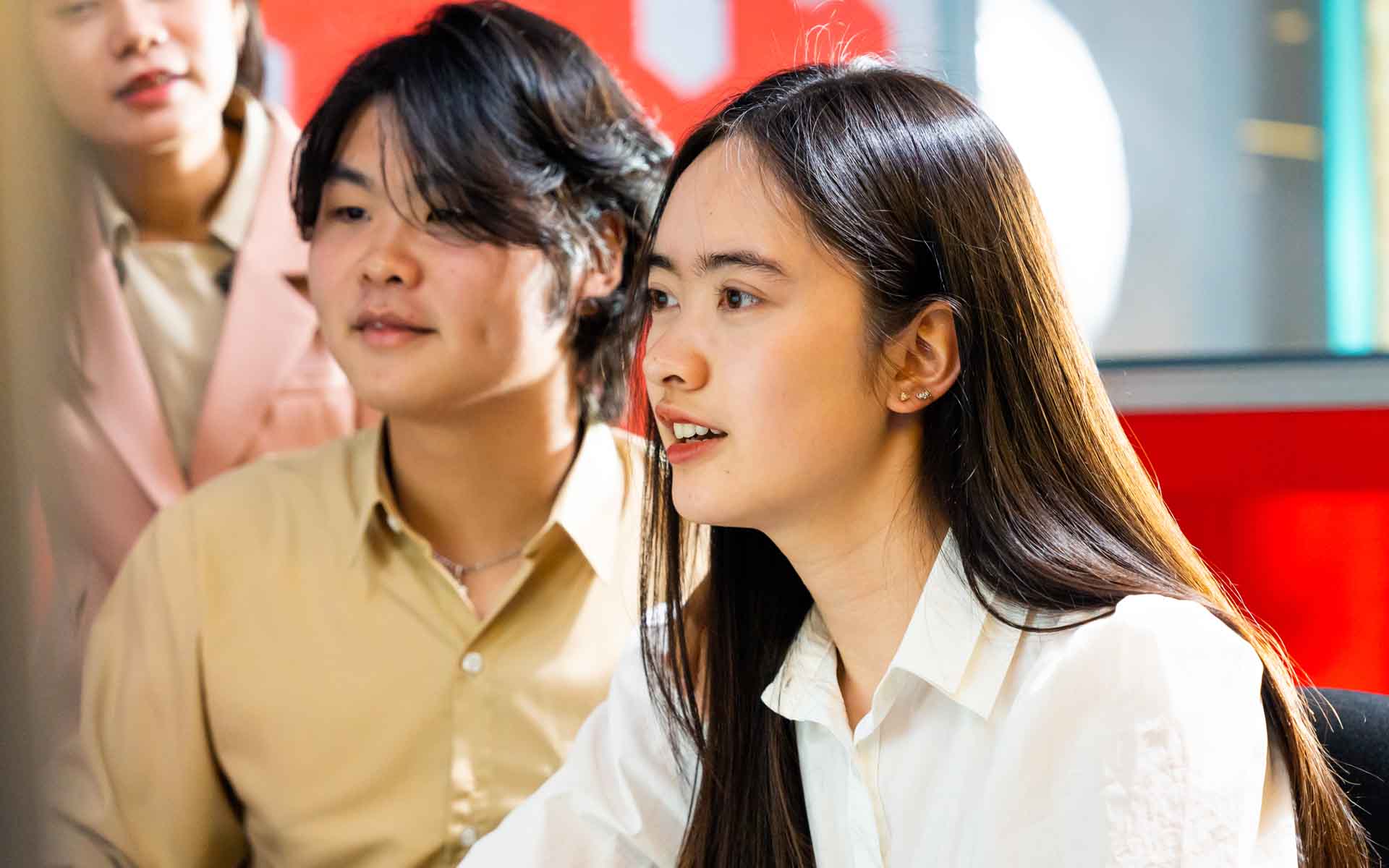 a girl student looking at a computer screen with her friends