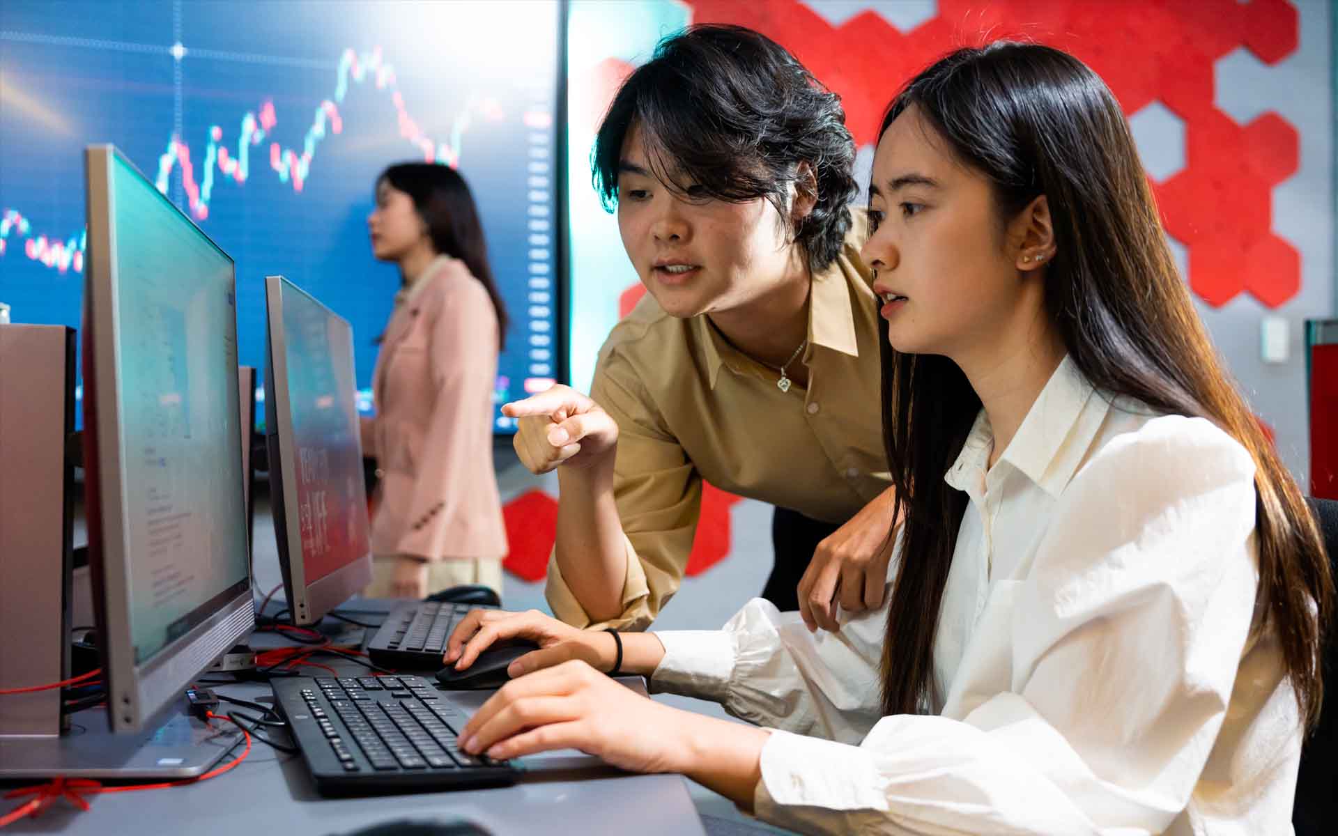 two students one girl one boy looking at a computer screen