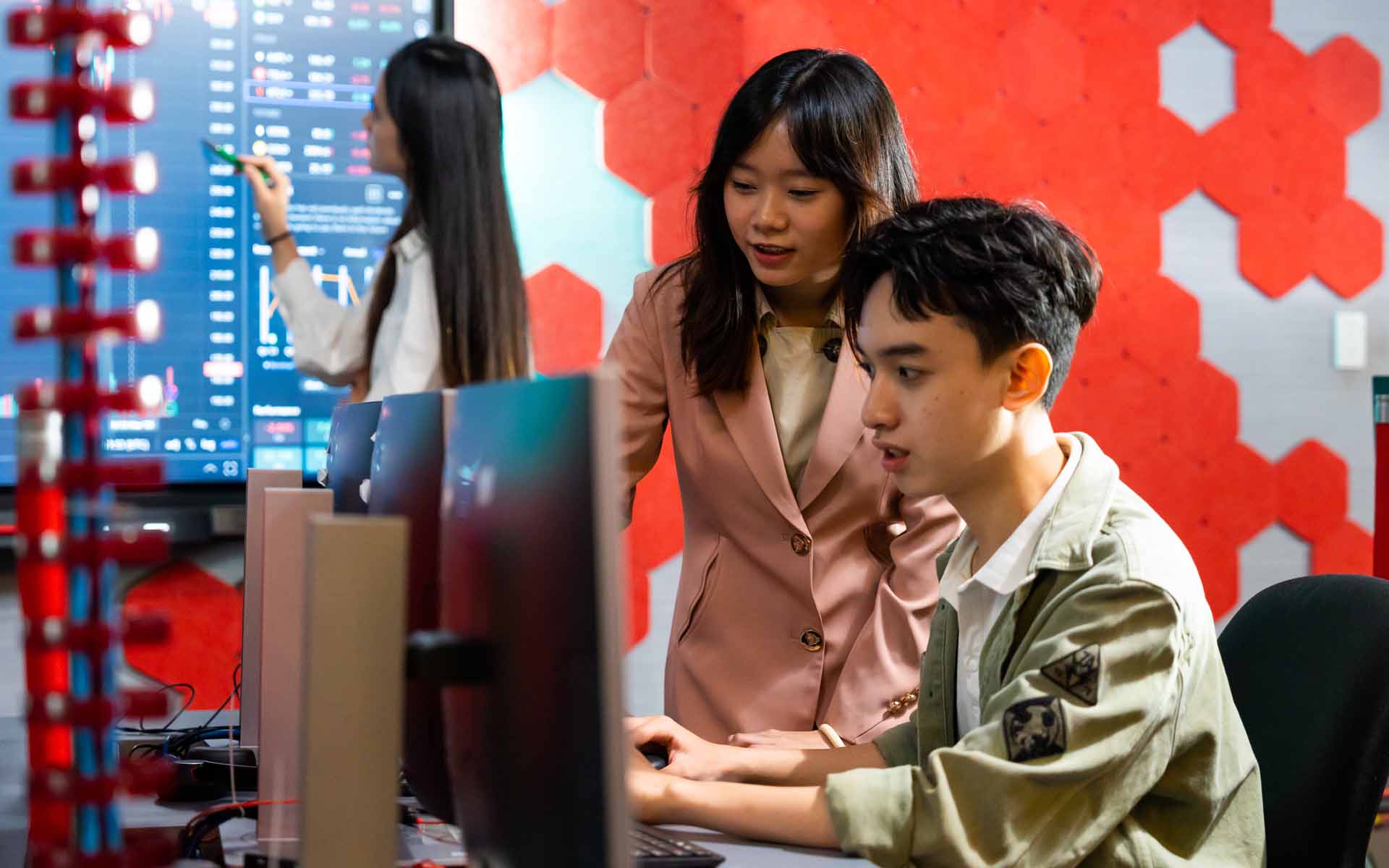 two students one girl and one boy looking at a computer screen