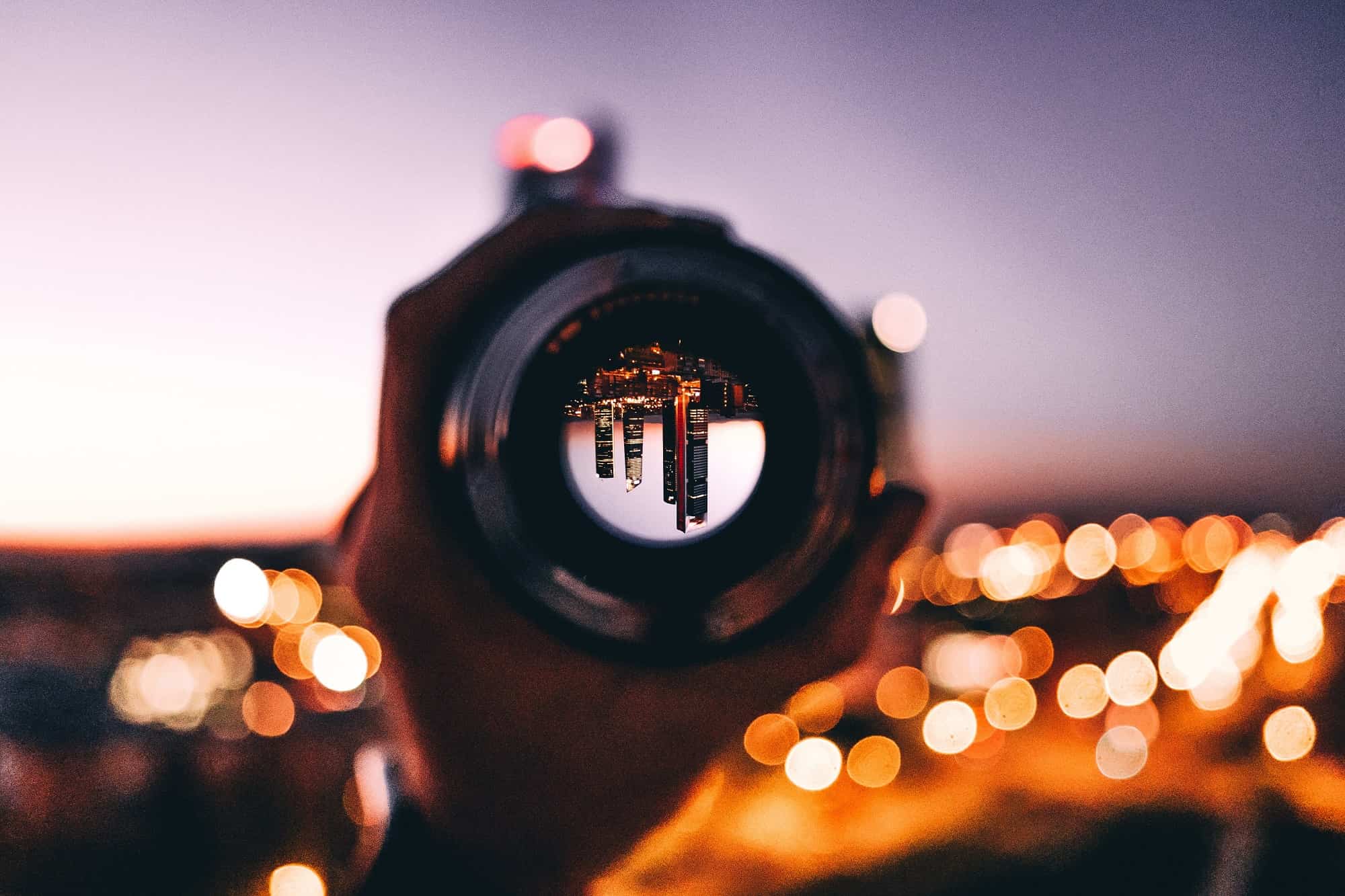 Camera lens in hand by night