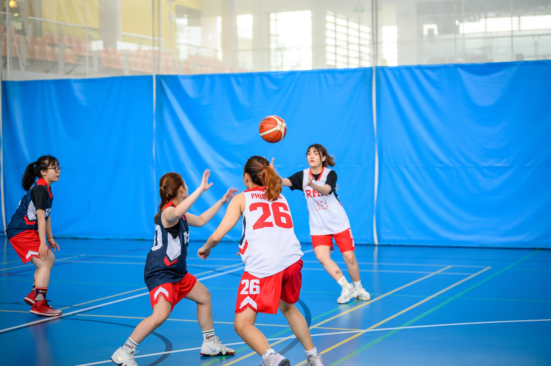 Women playing basketball against each other.