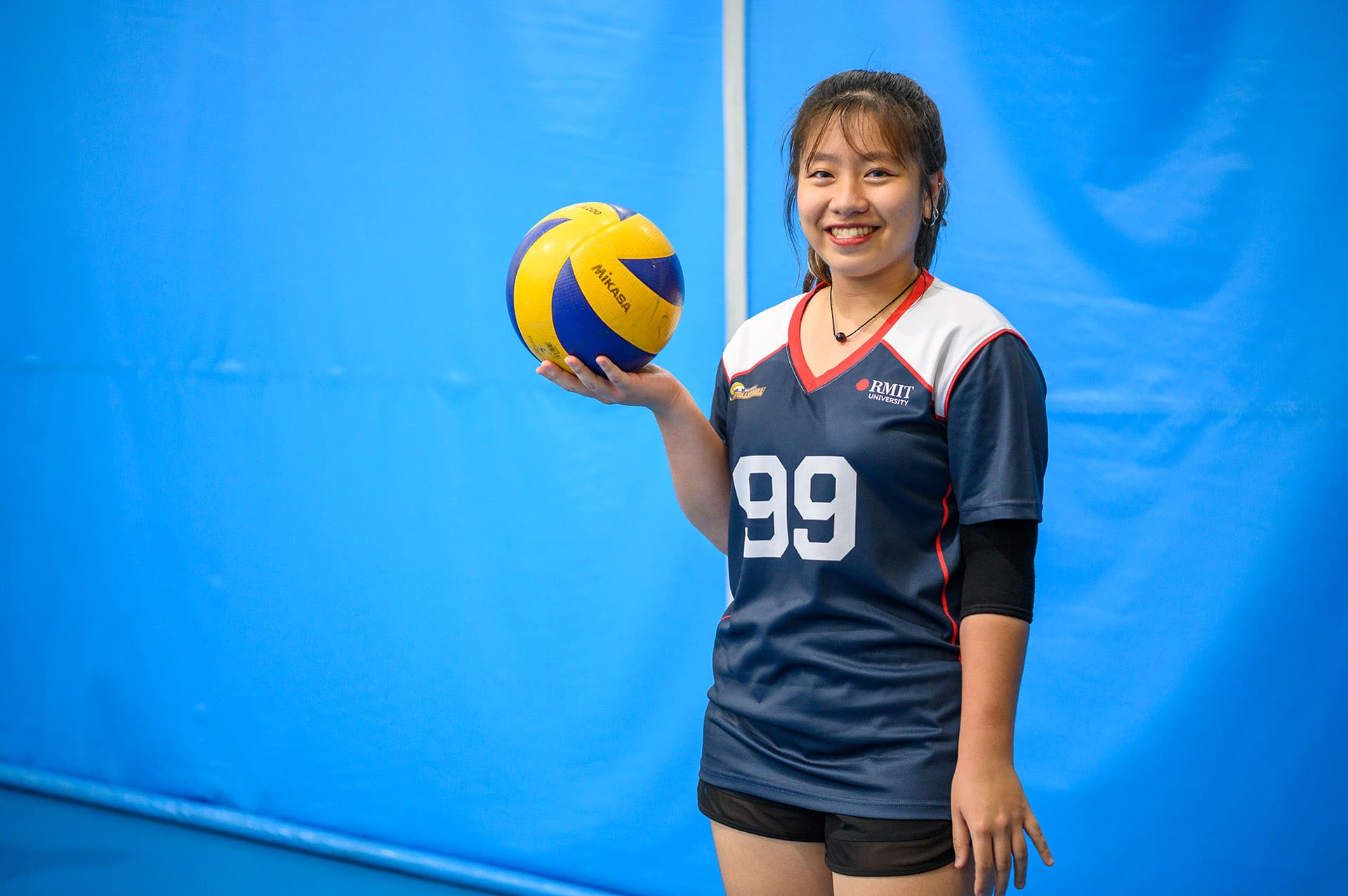 SGS volleyball player holding a volleyball.